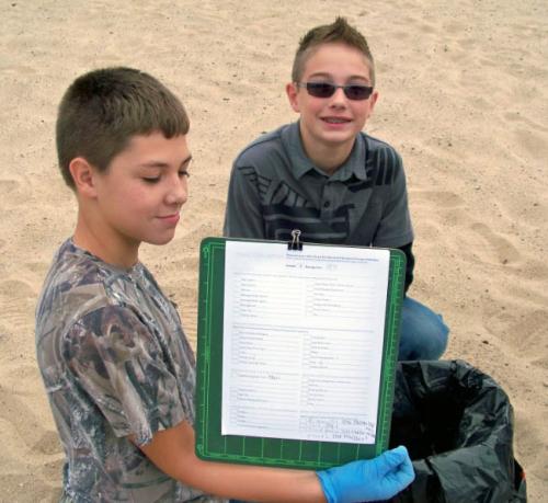 Two boys tracking Adopt-A-Beach clean up image.